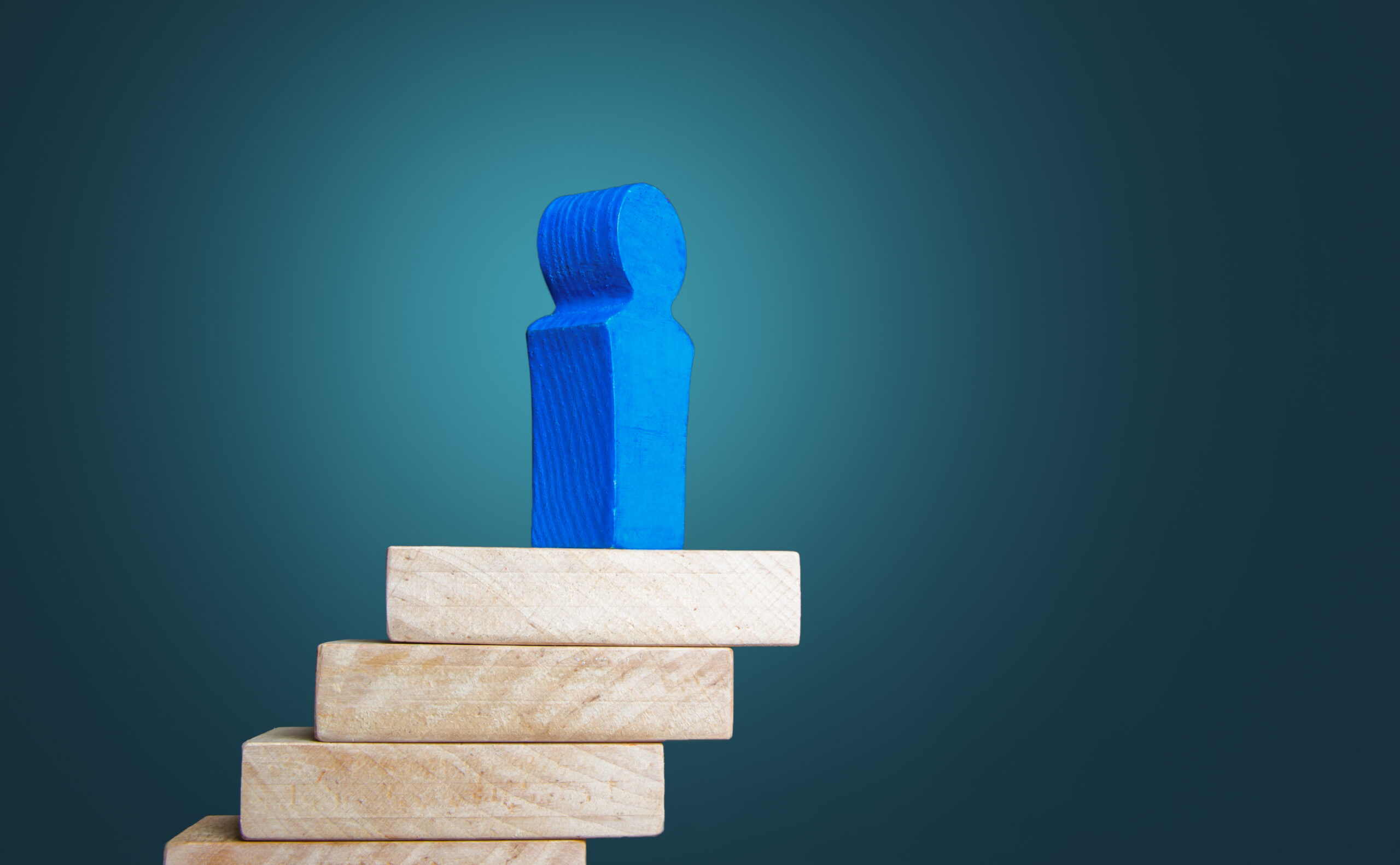 Wooden block figures showing career growth